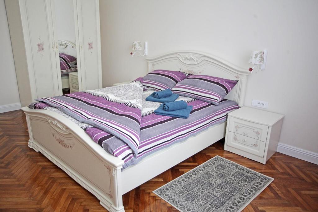 a bedroom with a bed with purple sheets and a mirror at City Center Belgrade Queen Apartment Skadarlija in Belgrade