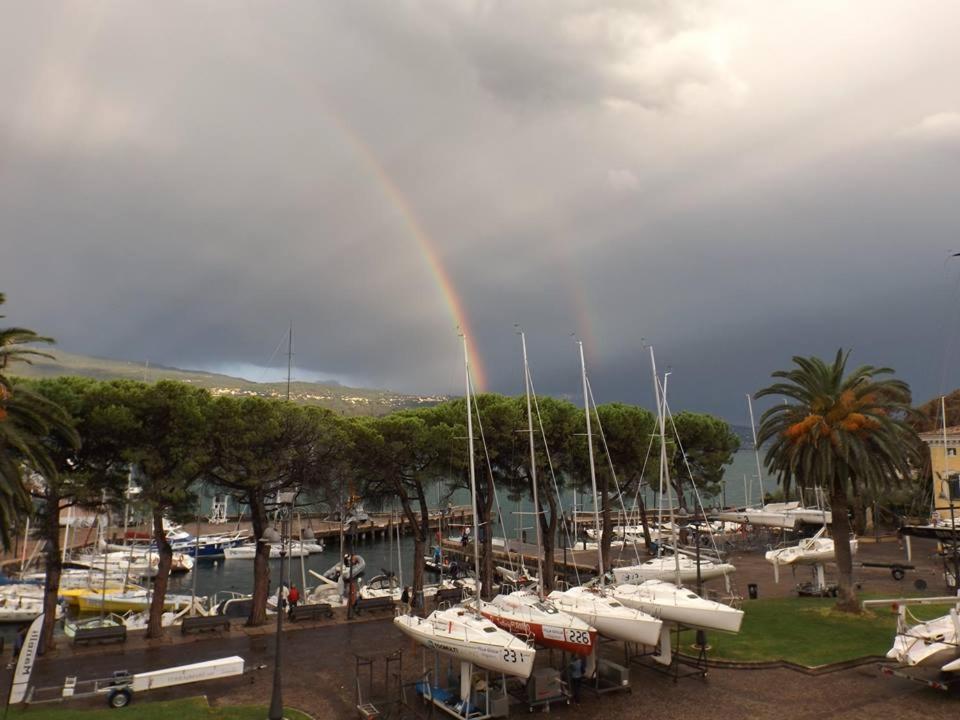 un arcobaleno sopra un porto turistico con barche in acqua di appartamento Le Vele a Gargnano
