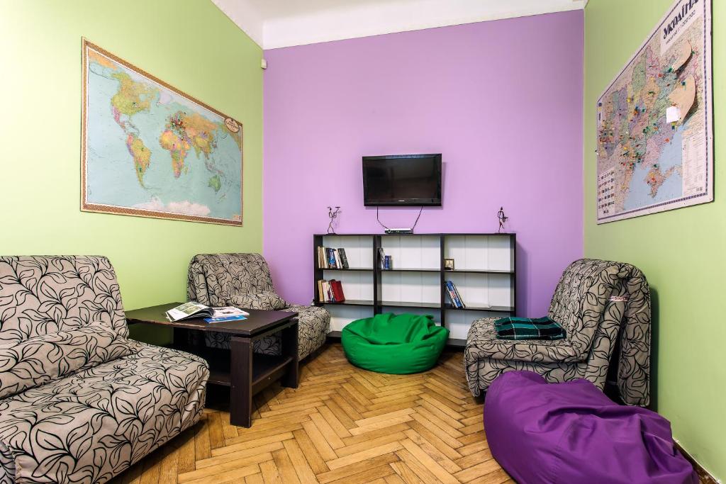 a living room with two chairs and a tv at Centrum Hostel in Lviv