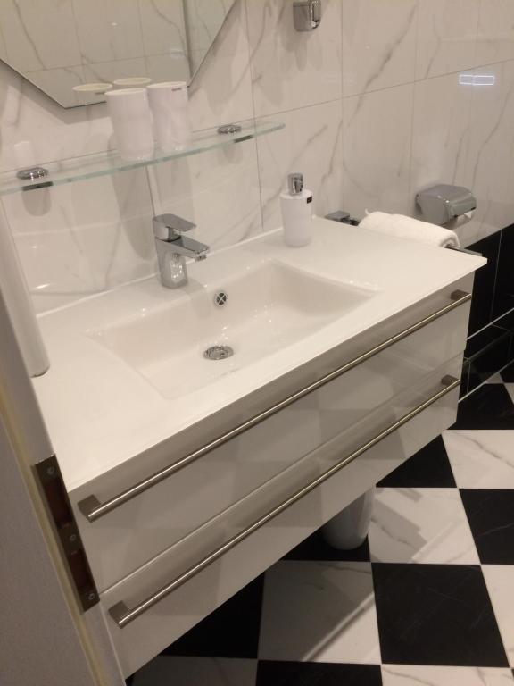 La salle de bains est pourvue d'un lavabo blanc et d'un miroir. dans l'établissement Hotel Villa Wittstock, à Burg