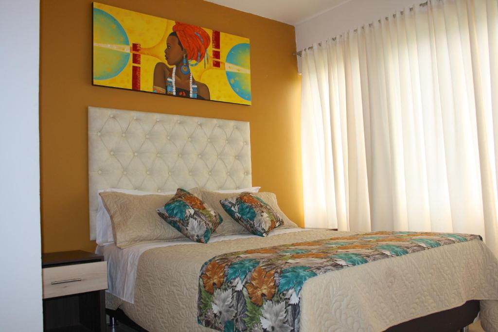 a bedroom with a bed and a painting on the wall at Hotel San Blass in La Unión