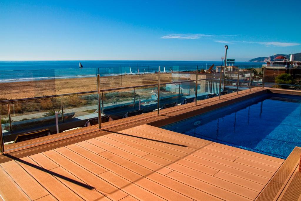 a swimming pool with a view of the beach at Apartaments Maritim in Castelldefels