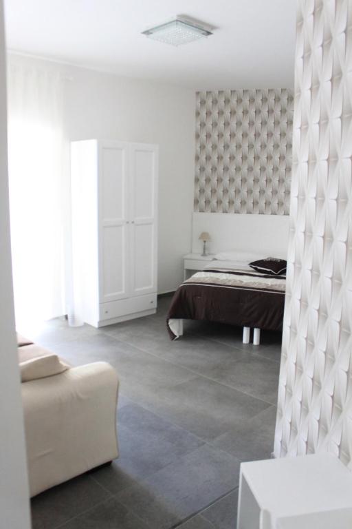 una camera bianca con un letto e un divano di B&B Alambrado Rooms & Suites a Napoli