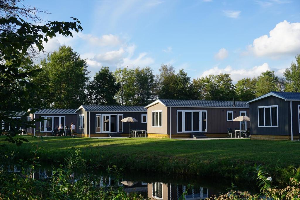 a row of modular homes next to a body of water at Chalets It Wiid in Eernewoude
