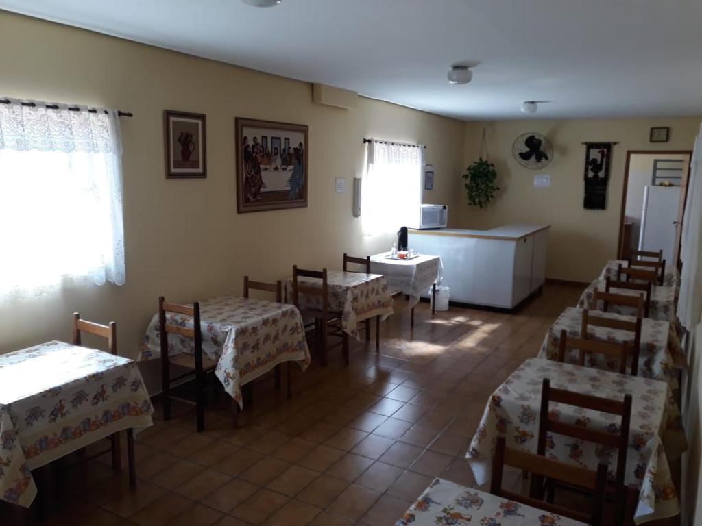 a dining room with tables and chairs in a room at HOTEL LAREIRA in São José dos Campos