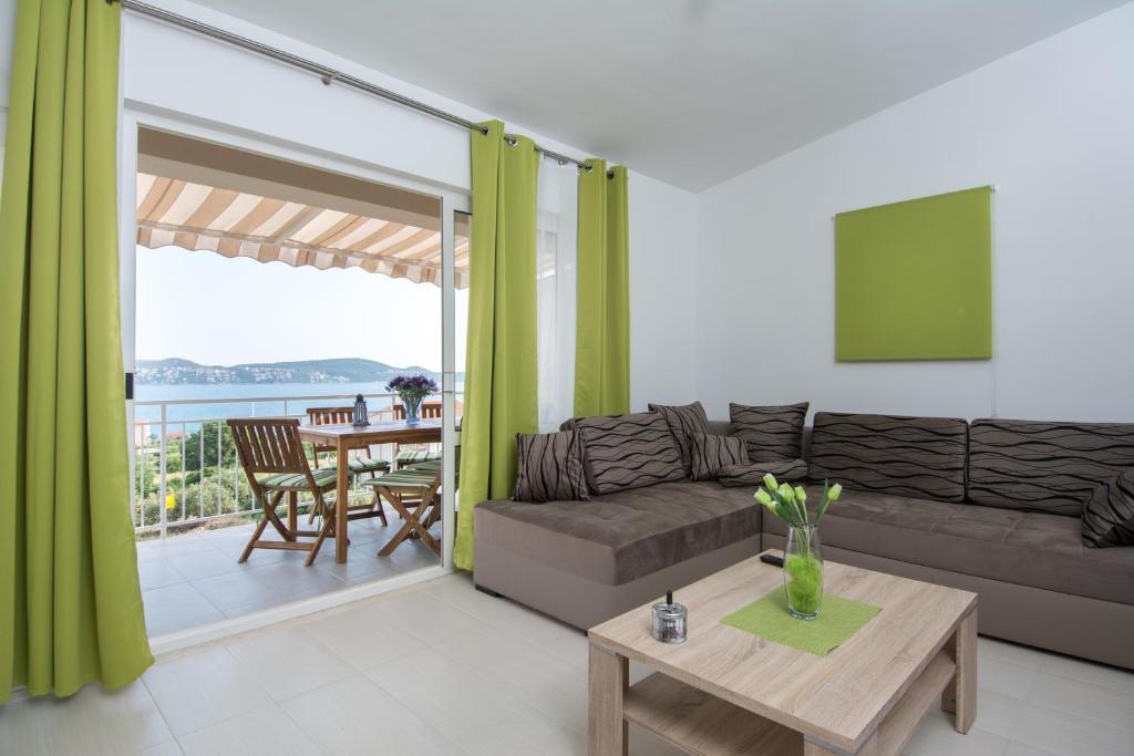 uma sala de estar com um sofá e uma mesa em Apartments Iva em Trogir