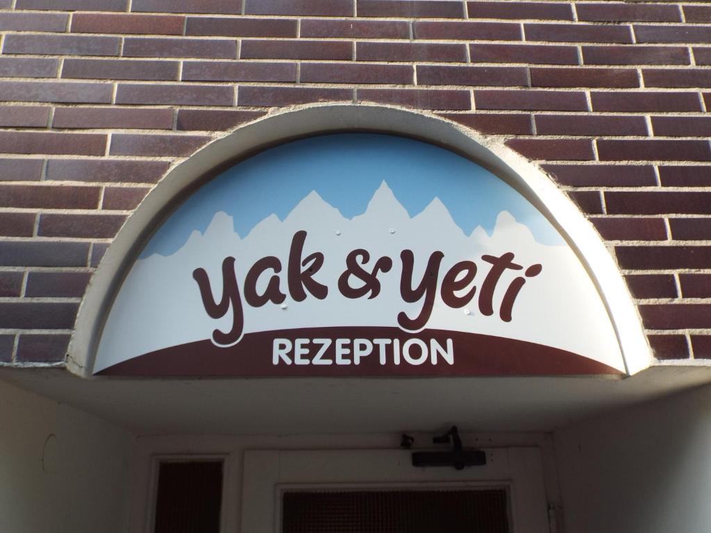 un cartello sopra la porta di un edificio di Pension Yak und Yeti a Bad Honnef am Rhein