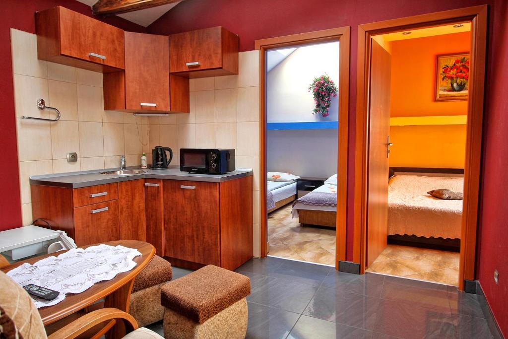 a kitchen with a table and a room with a bedroom at Pokoje u Eli in Szczawnica