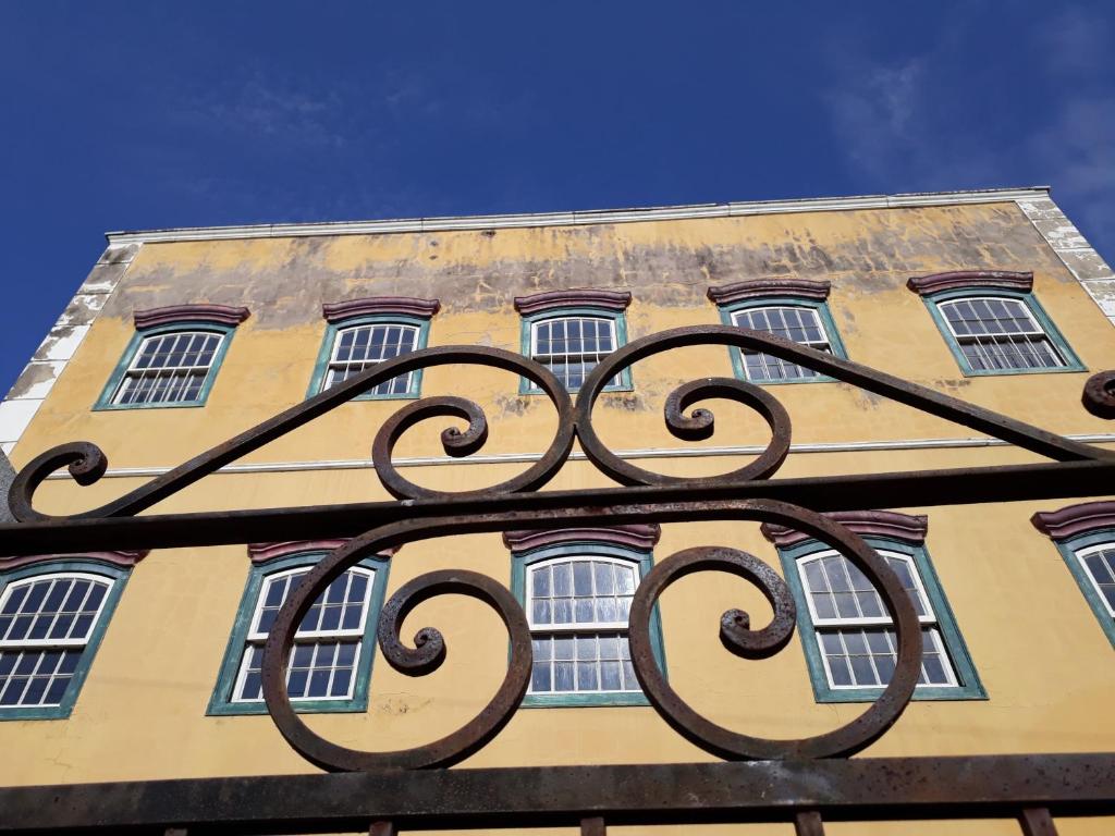 a building with windows and a iron fence in front at Casarão do DU in Campinas