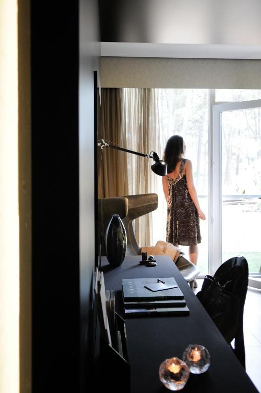a woman standing in front of a window holding a microphone at Evidencia Belverde Hotel in Amora