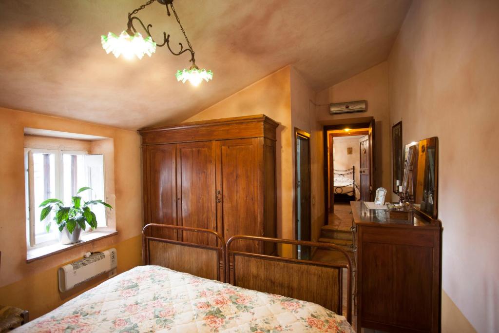 - une chambre avec un lit et une armoire en bois dans l'établissement Locanda della Casella, à Cineto Romano