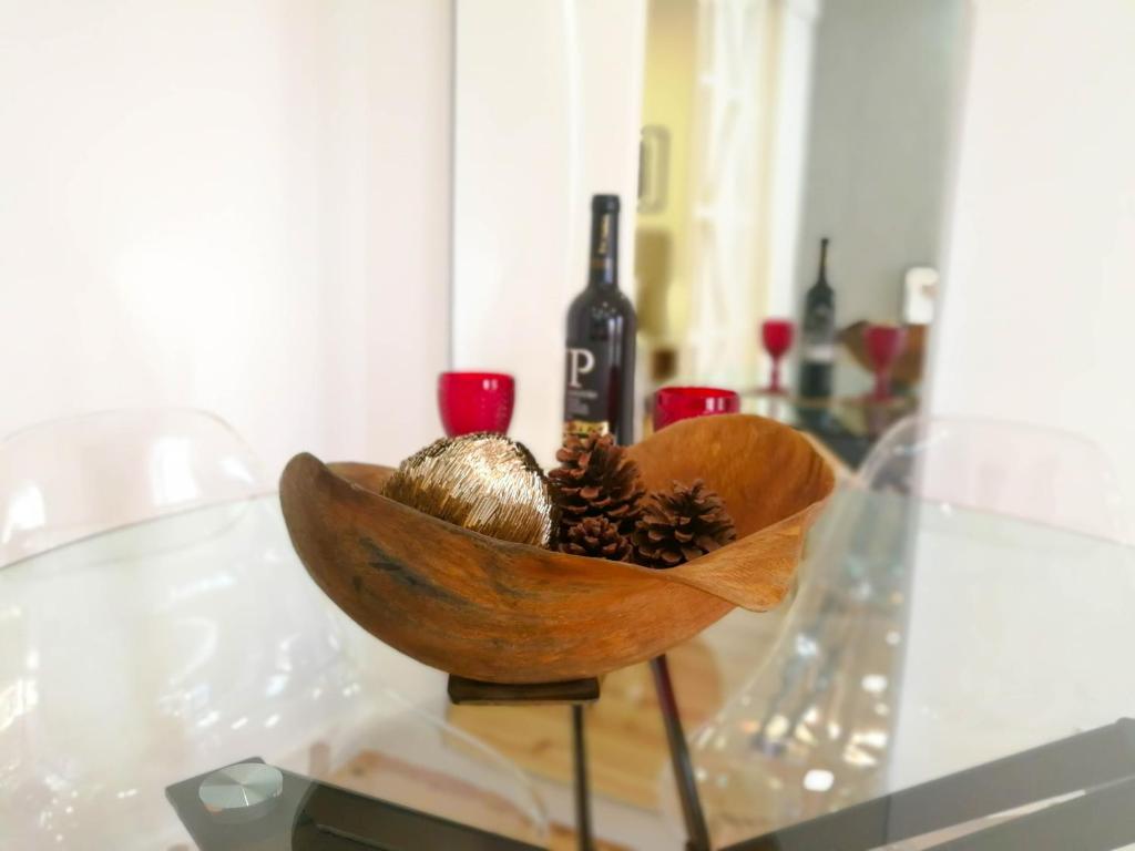 a wooden bowl with a bottle of wine on a glass table at Beautiful & Unique Alfama in Lisbon