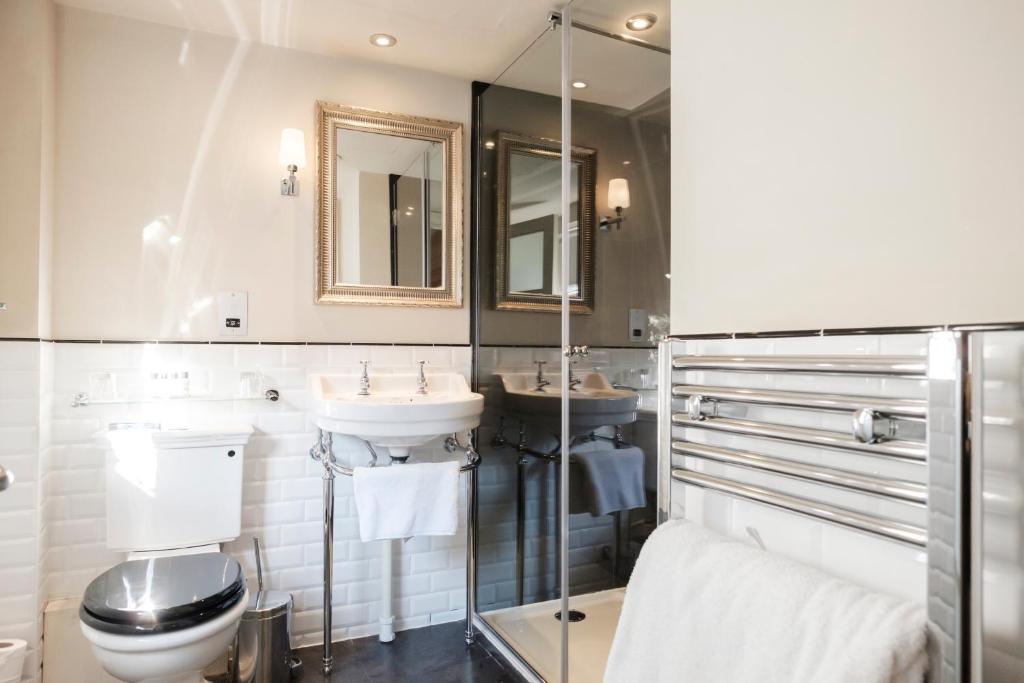 a bathroom with two sinks and a toilet at The White Swan Hotel in Stratford-upon-Avon