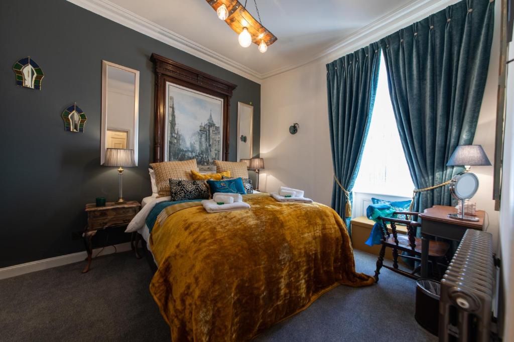1 dormitorio con 1 cama grande y paredes azules en The Jeffrey Street Retreat, en Edimburgo