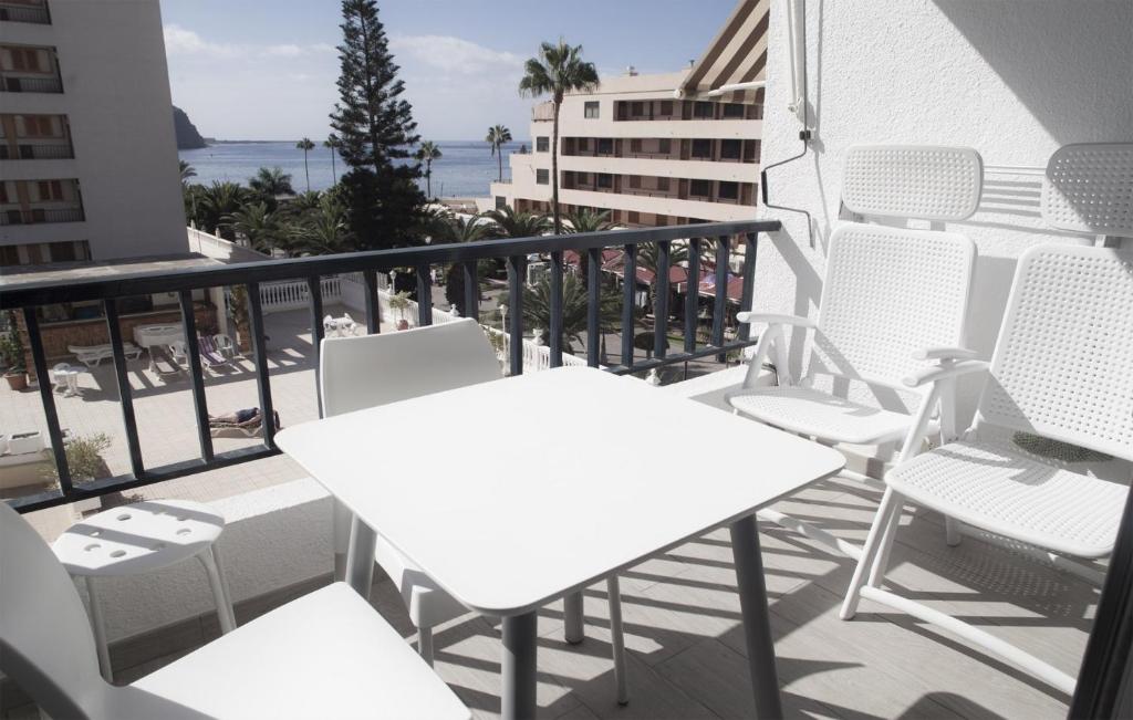 ロス・クリスティアーノスにあるFayser FREE WIFIの白いテーブルと椅子、海を望むバルコニー
