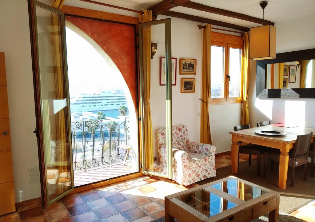 a living room with a large window and a table at Barceloneta Ramblas Apartments in Barcelona