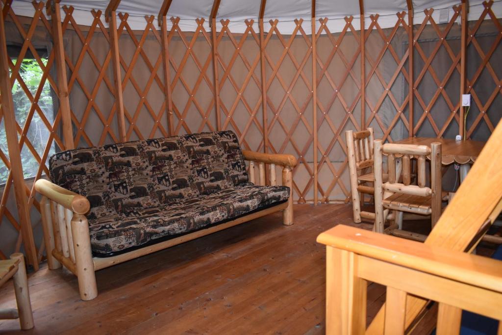 un soggiorno con un divano e una poltrona di Tall Chief Camping Resort Yurt 5 a Pleasant Hill