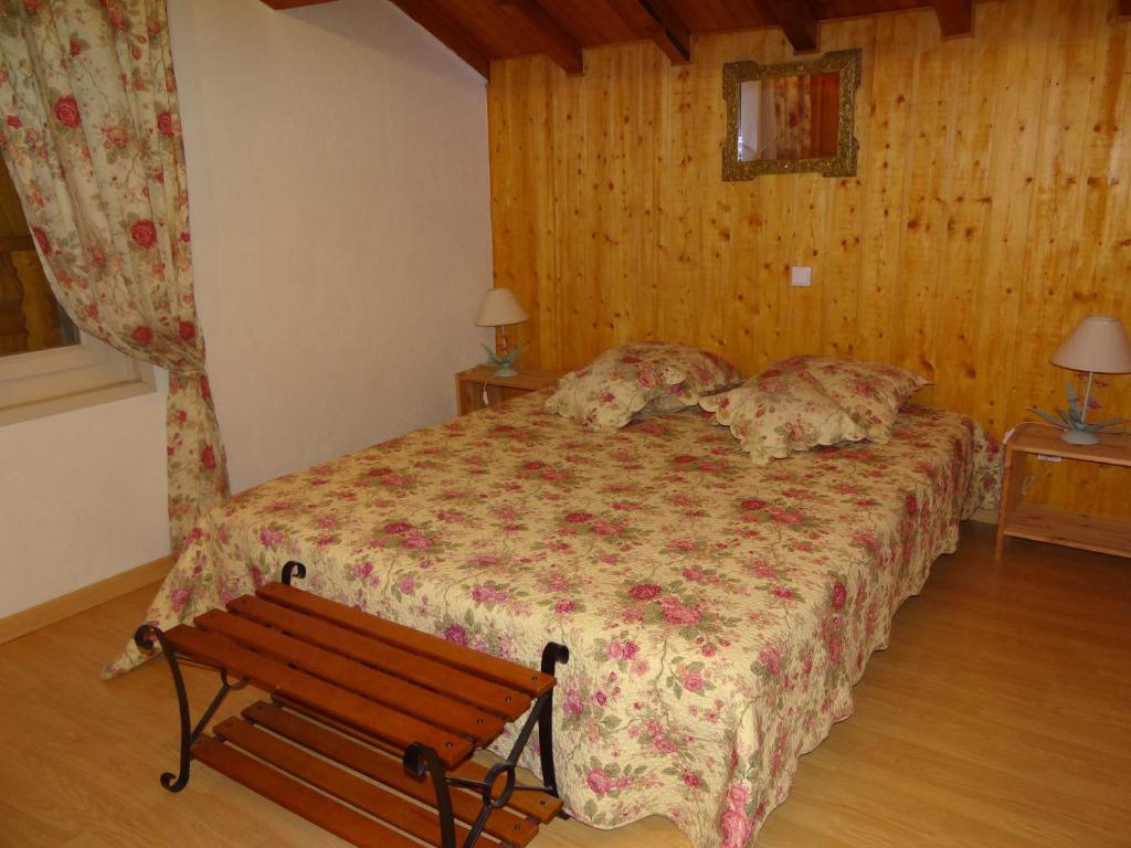 a bedroom with a bed with a bench in it at Oustals De Lavail in Ascou