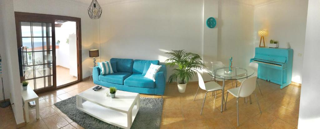 プエルト・デ・サンティアゴにあるElita el varadero FREE WIFIのリビングルーム(青いソファ、ガラスのテーブル付)