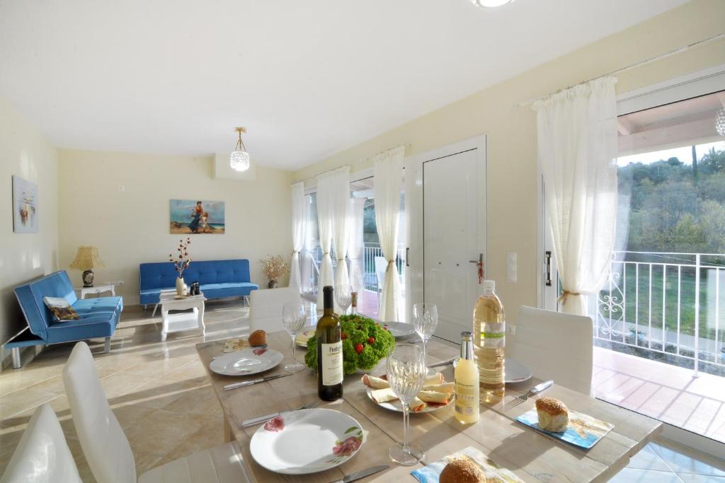 een woonkamer met een tafel met wijnflessen bij Alexandras Forest View in Ágios Prokópios