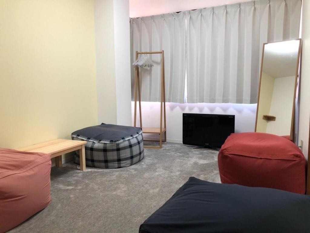 uma sala de estar com uma cama e uma televisão em First Hongo Building 202 / Vacation STAY 3355 em Chiba
