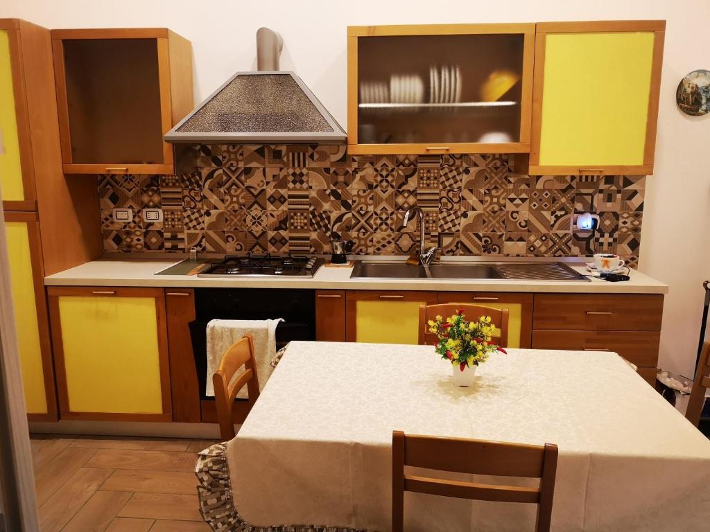 a kitchen with a table with a vase of flowers on it at Dimora Ruggiero in Naples