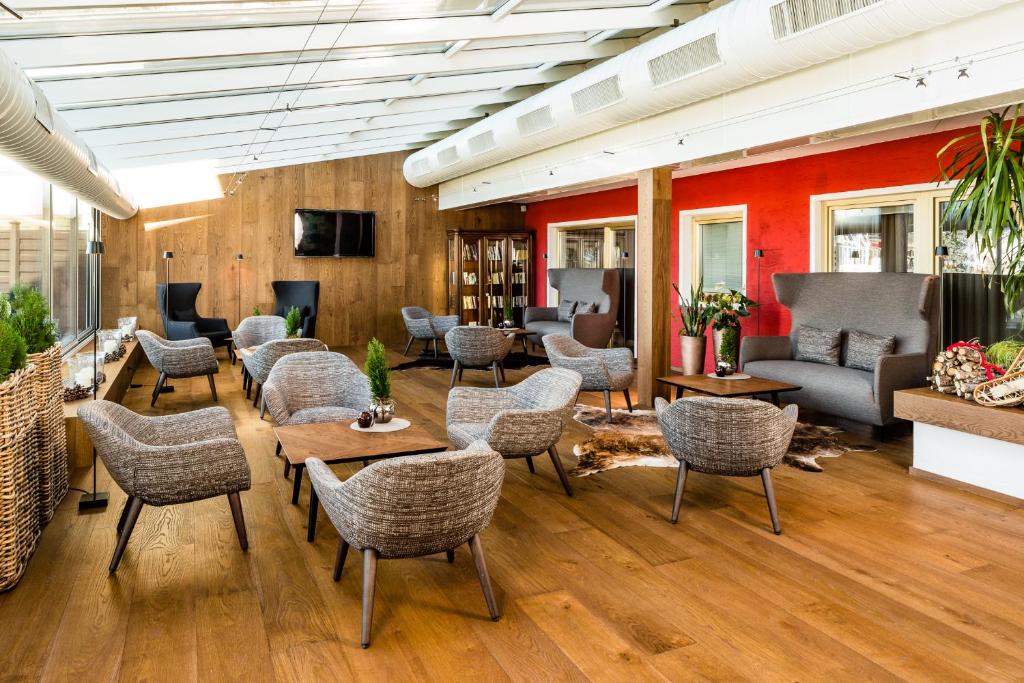 a lobby with chairs and tables in a room at Hotel Alpenroyal - The Leading Hotels of the World in Selva di Val Gardena