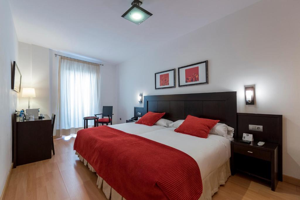 a bedroom with a large bed with a red blanket at Itaca Salamanca by Soho Boutique in Salamanca