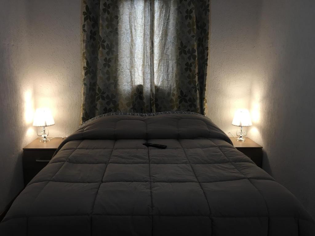una camera con un grande letto con due lampade di Cantinho da alice a Campos do Jordão