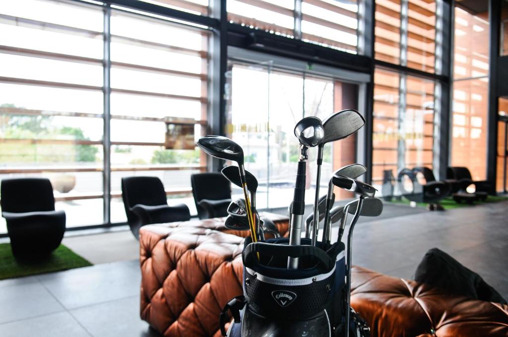 a room with a table with a bunch of golf clubs at Evidencia Belverde Hotel in Amora