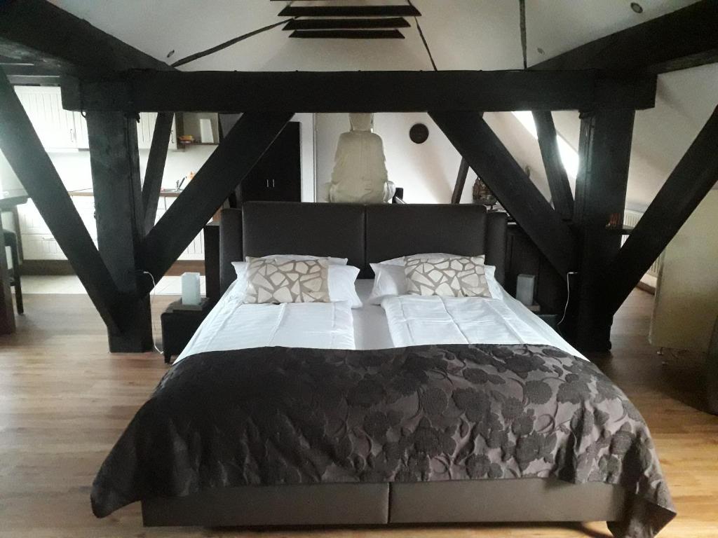 a bedroom with a black bed with white sheets and pillows at Zum alten Krug in Wangerland