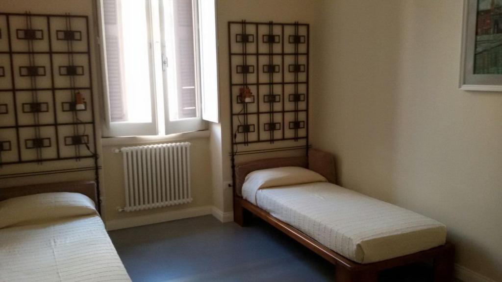una piccola camera con due letti e una finestra di daniel's house a Bari