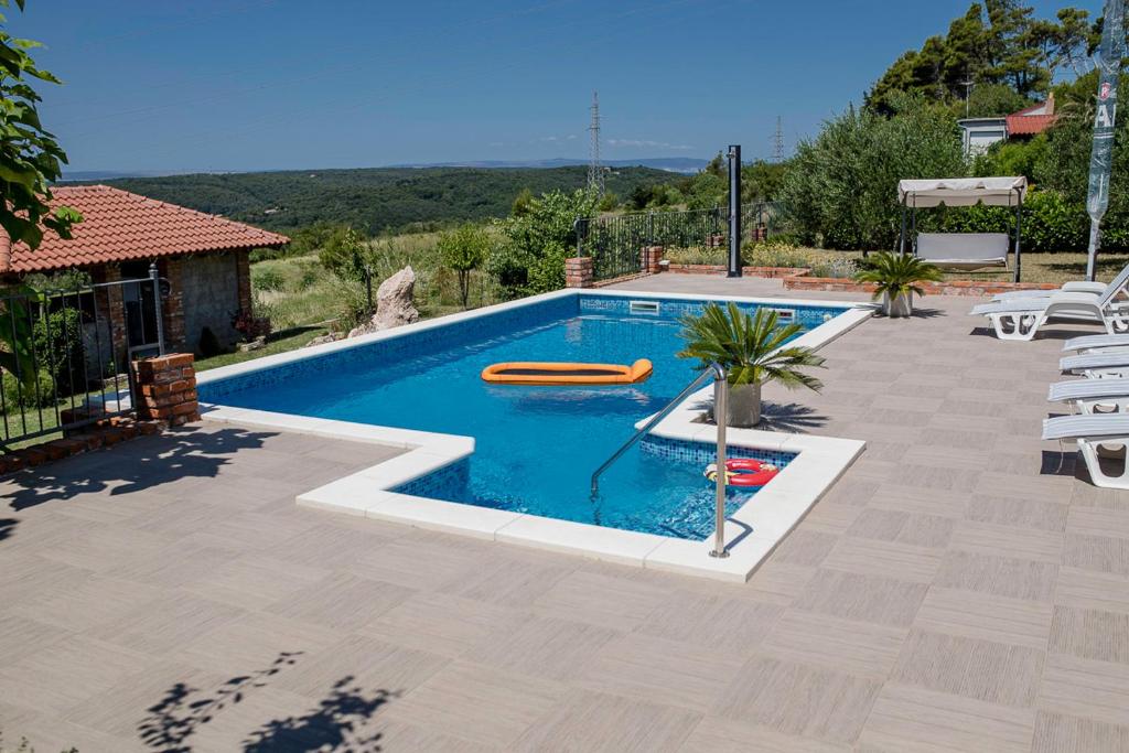 a swimming pool with a pool noodle in a backyard at VILLA LIDIA in Mundanije