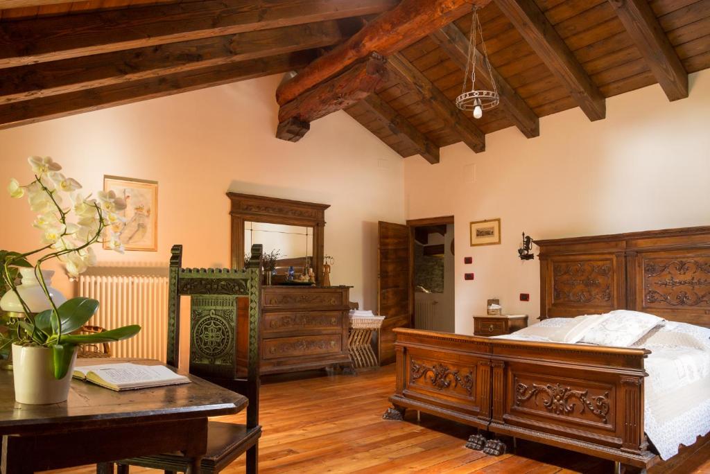 una camera con letto in legno e tavolo in legno di B&B La Tour de Villa ad Aosta