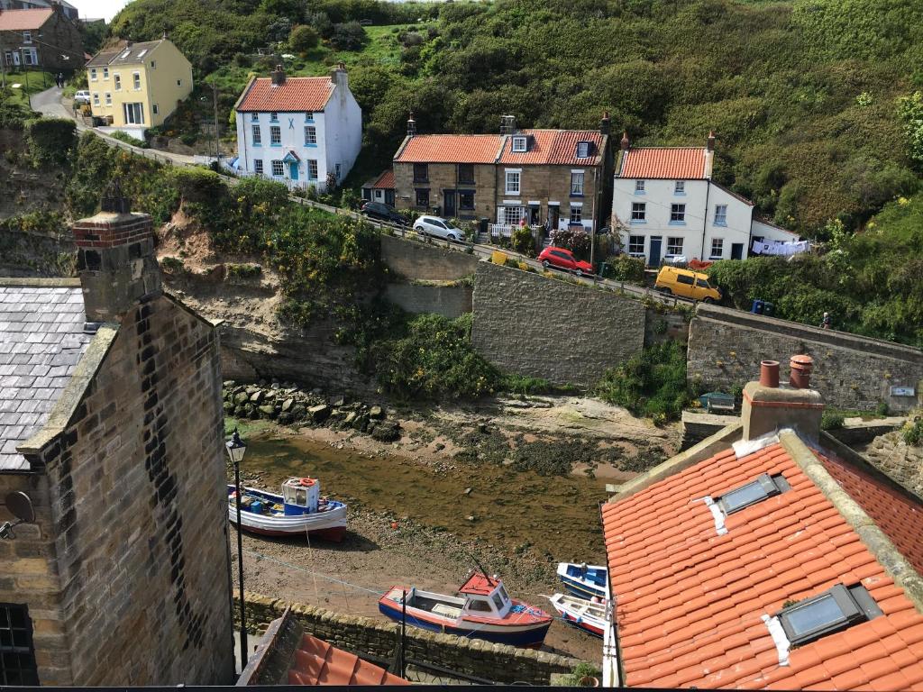 een groep boten in een waterlichaam met gebouwen bij Ravenscraig House in Staithes
