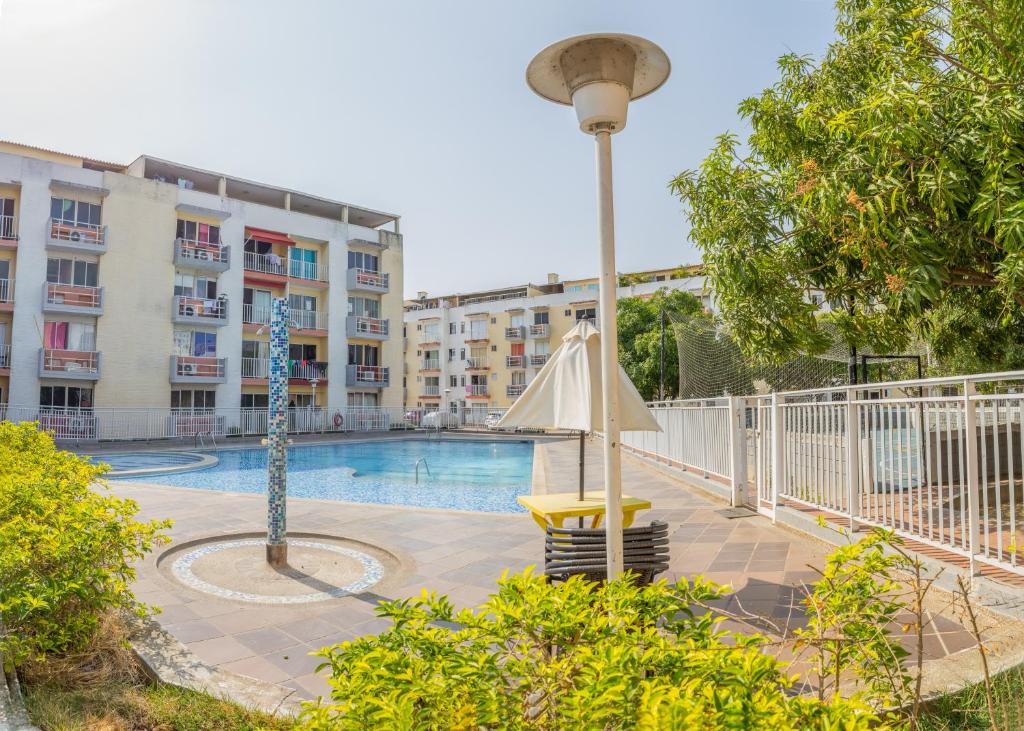 a swimming pool with an umbrella and a street light at Blue Pearl Cartagena in Cartagena de Indias
