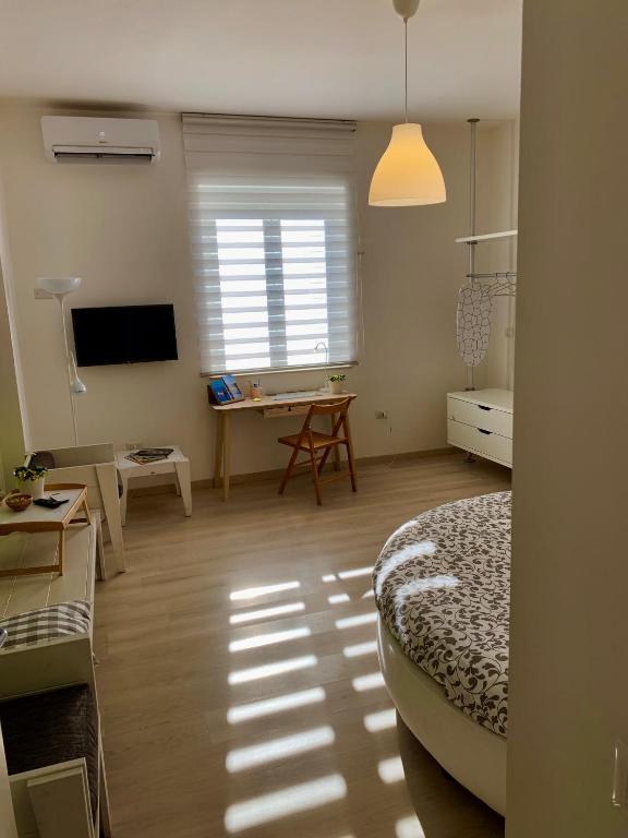 a room with a bed and a desk and a television at Casa Francesco in Bolsena
