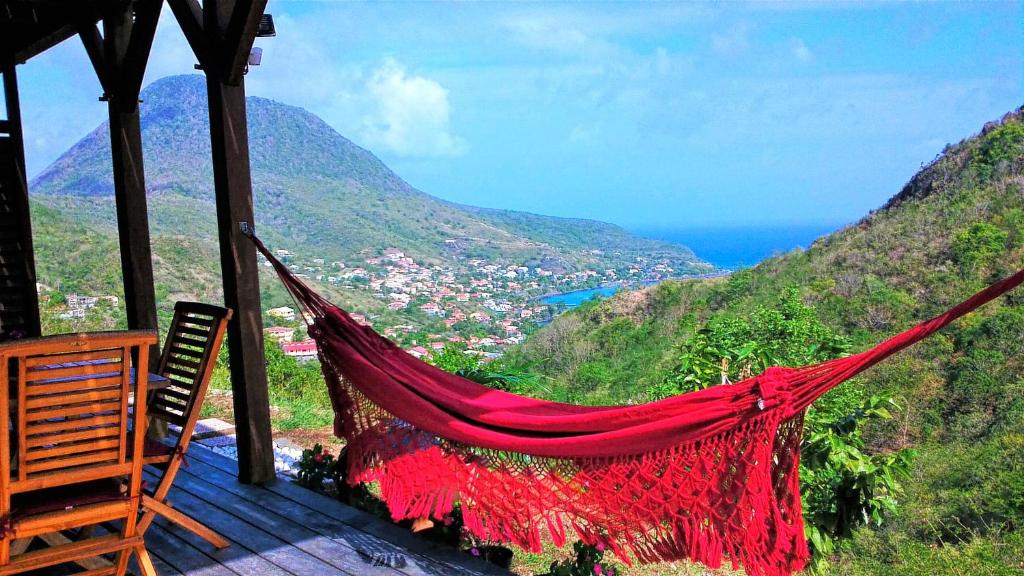 a hammock on a house with a view of the mountains at Le Pic De La Buse in Les Anses-dʼArlets