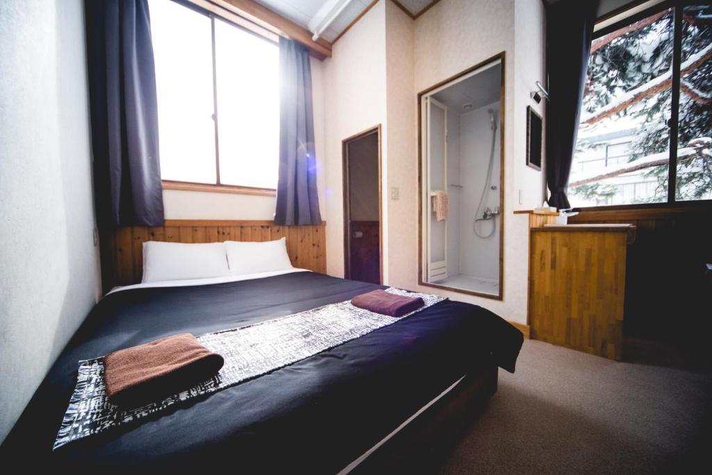 A bed or beds in a room at Hakuba Cortina Lodge