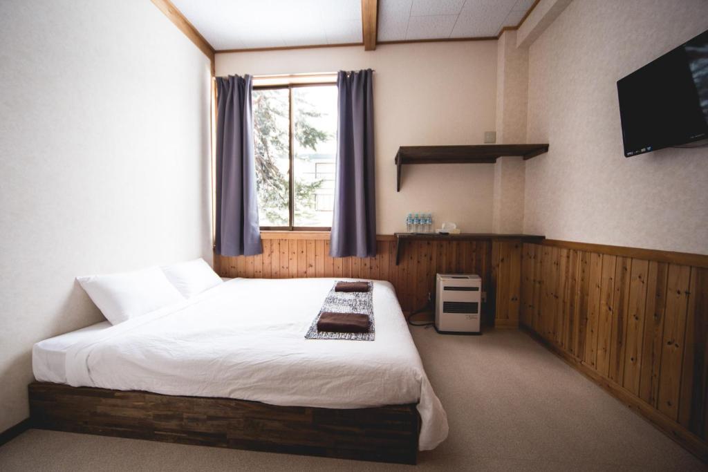 Postel nebo postele na pokoji v ubytování Hakuba Cortina Lodge