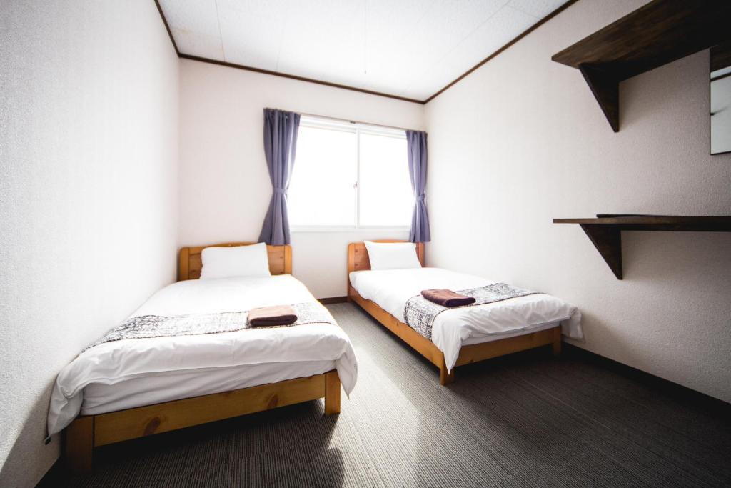 Postel nebo postele na pokoji v ubytování Hakuba Cortina Lodge
