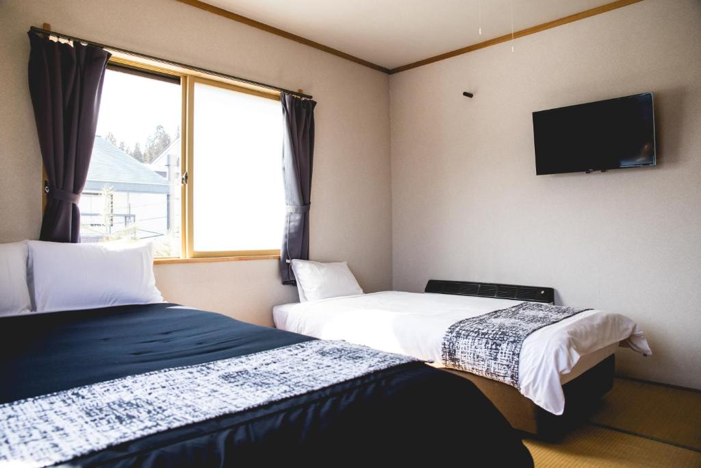 Postel nebo postele na pokoji v ubytování Hakuba Cortina Lodge