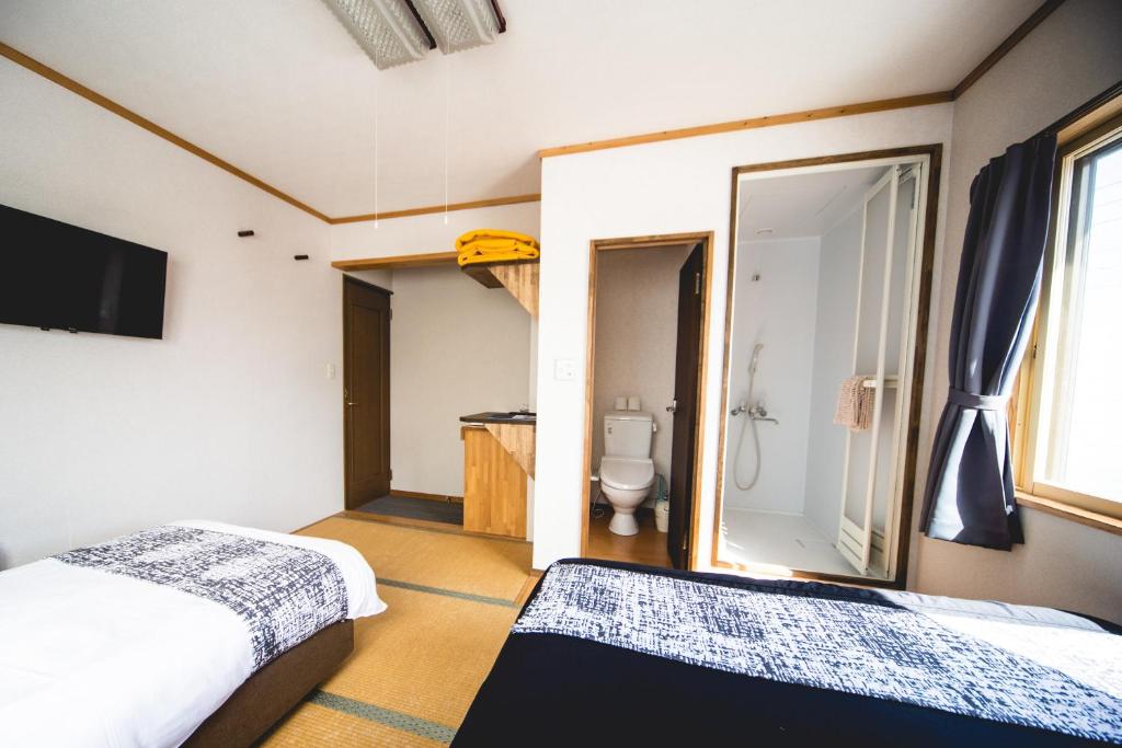 Postel nebo postele na pokoji v ubytování Hakuba Cortina Lodge