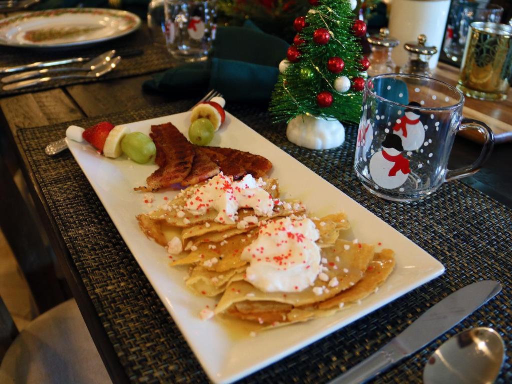 a plate of nachos on a table with a christmas tree at Sheridan House Inn- Adult Only Accommodation in Williams