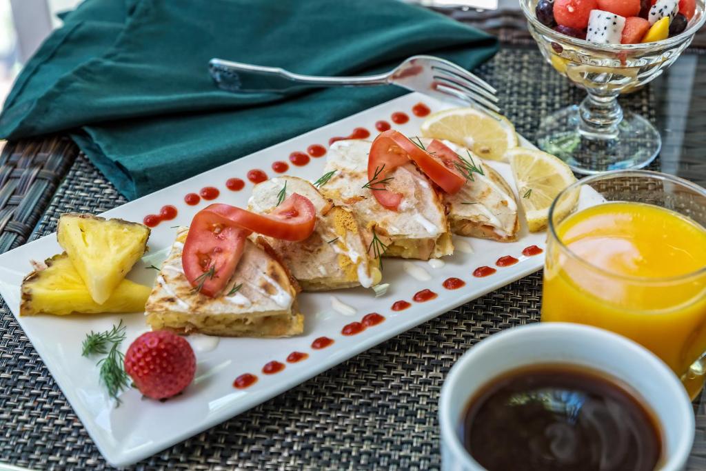 a plate of food with tomatoes and fruit on a table at Sheridan House Inn- Adult Only Accommodation in Williams