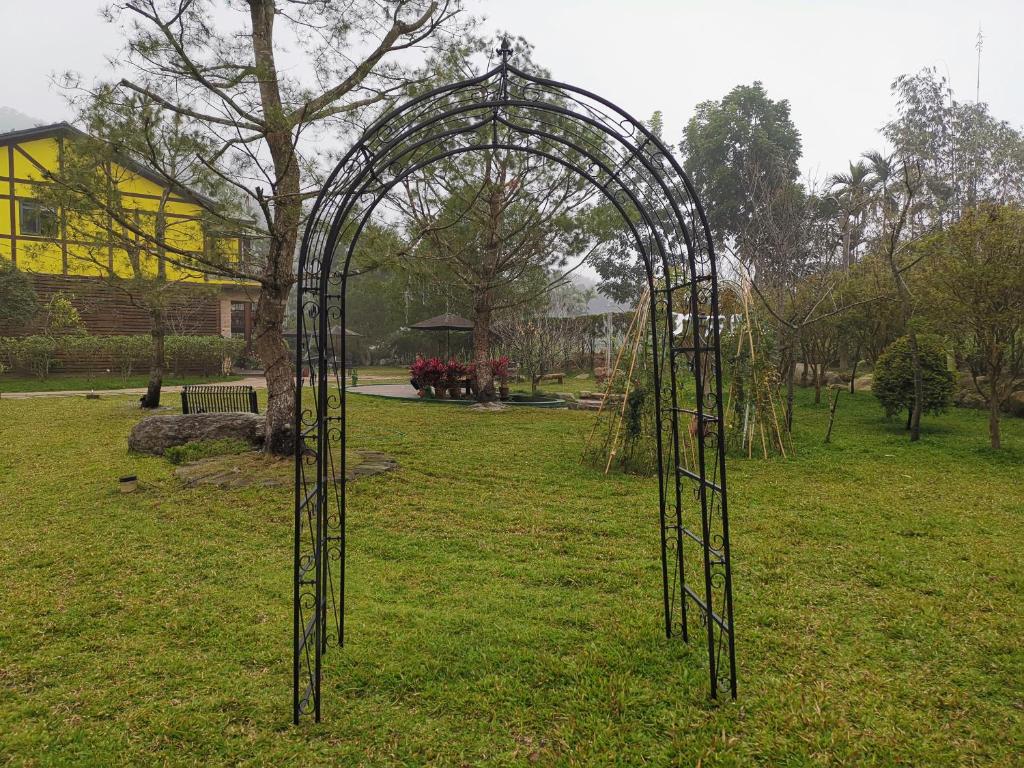 a metal arch in a field with a tree at Sitou Peach Villa B&amp;B in Lugu Lake