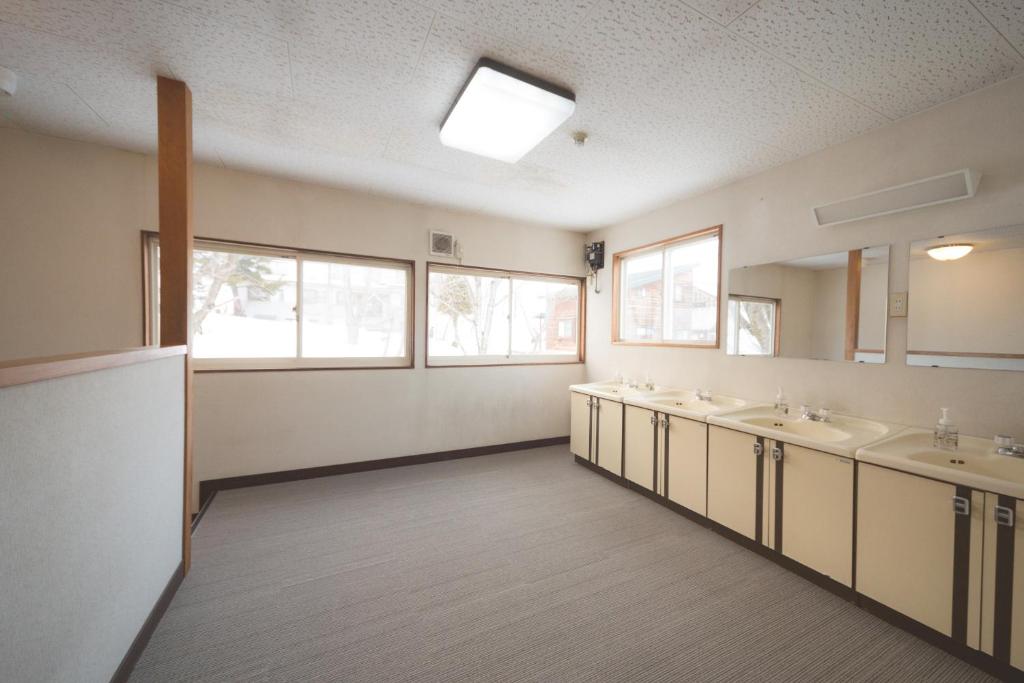 a large bathroom with two sinks and two mirrors at Hakuba Cortina Backpackers in Otari