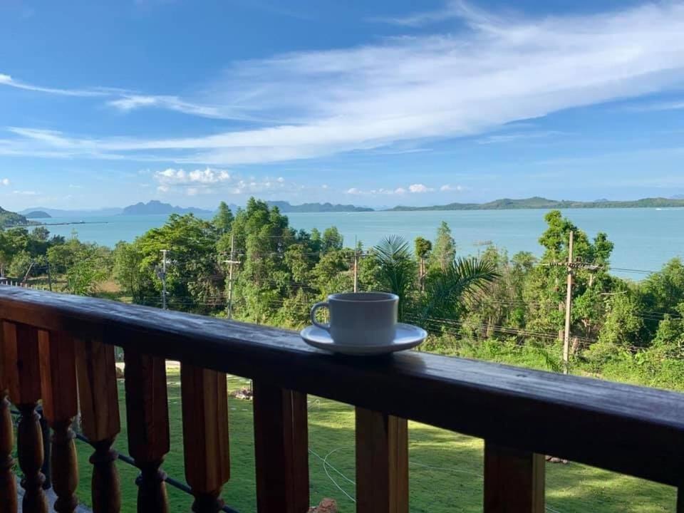 a cup of coffee sitting on the railing of a balcony at Resting Place Ko Yao Yai in Ko Yao Yai