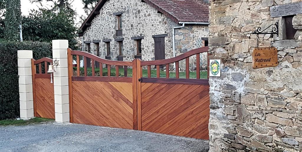 une porte en bois devant un bâtiment en pierre dans l'établissement Le COSY, à Saint-Yrieix-la-Perche