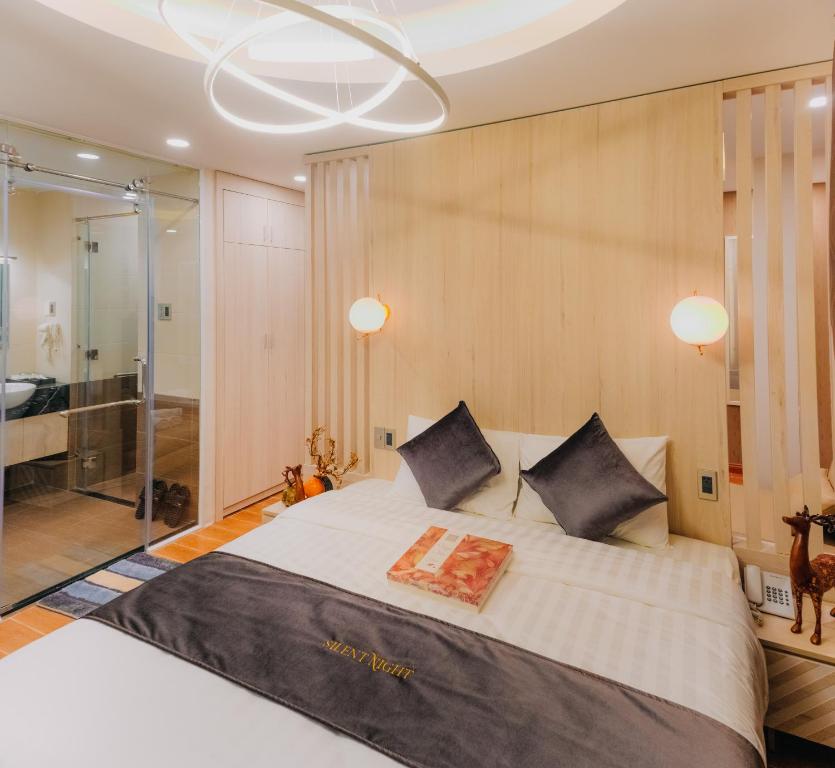 una camera con un grande letto bianco e una doccia di Silent Night Dem Lanh Hotel a Da Lat